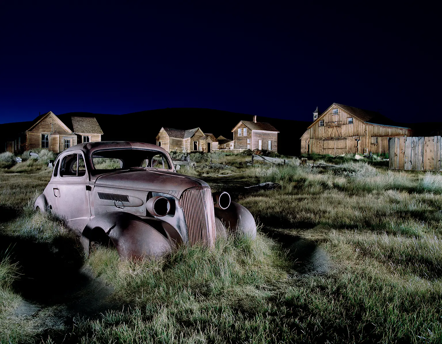 Wrack eines Auto liegt im Gras in der Ghost Town Bodie in Kalifornien