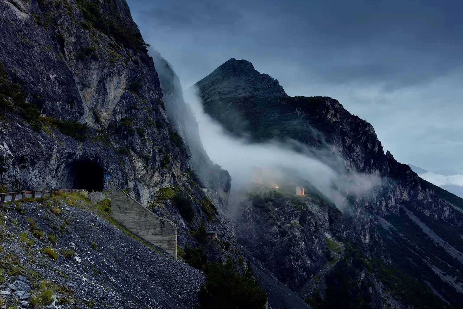 The ruins of two fortress towers on the pass summit of Torri di Fraele pass are covered in mist