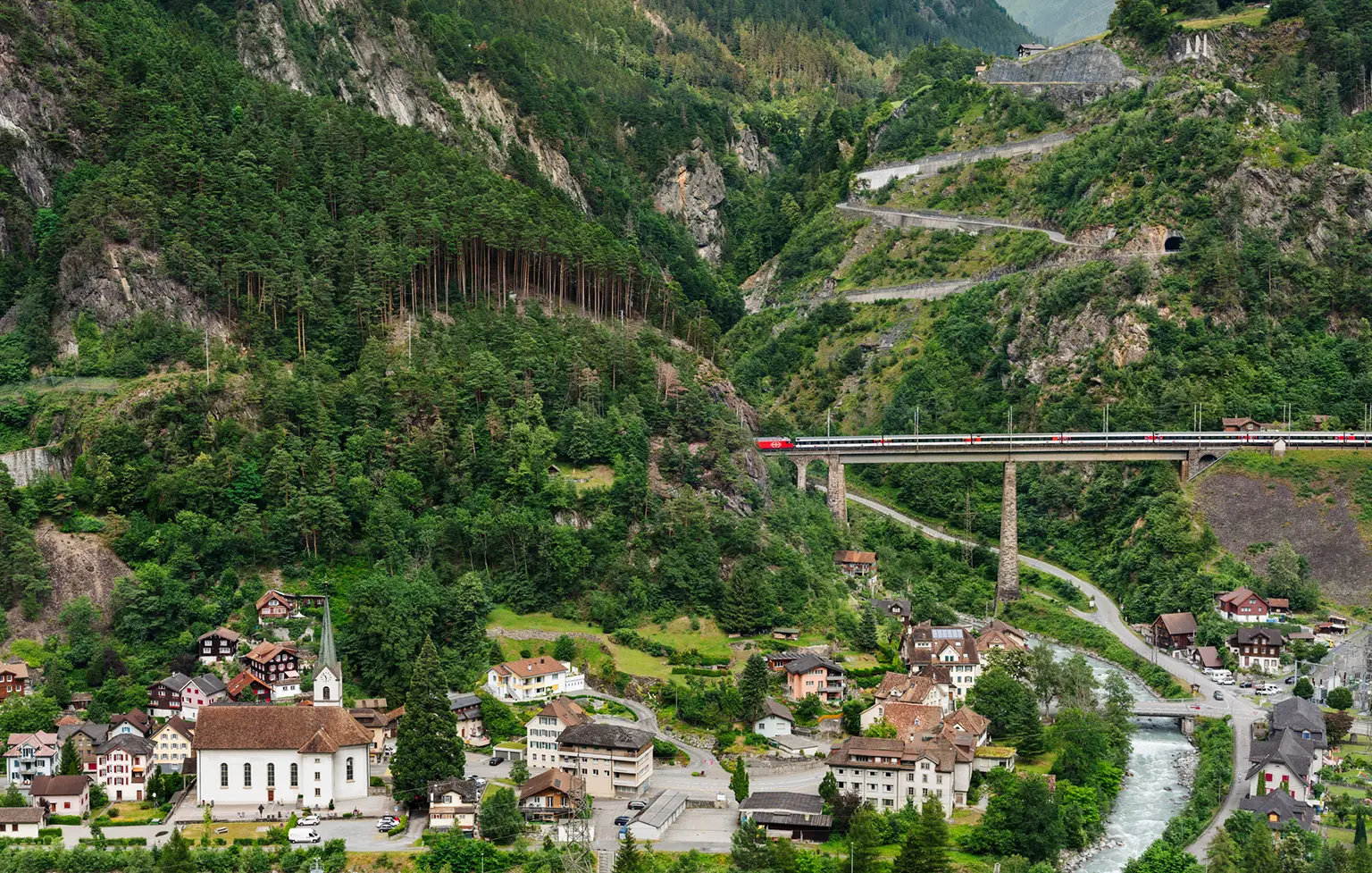 Zug auf der Gotthardbahnstrecke an der Chärstelenbachbrücke in Amsteg 