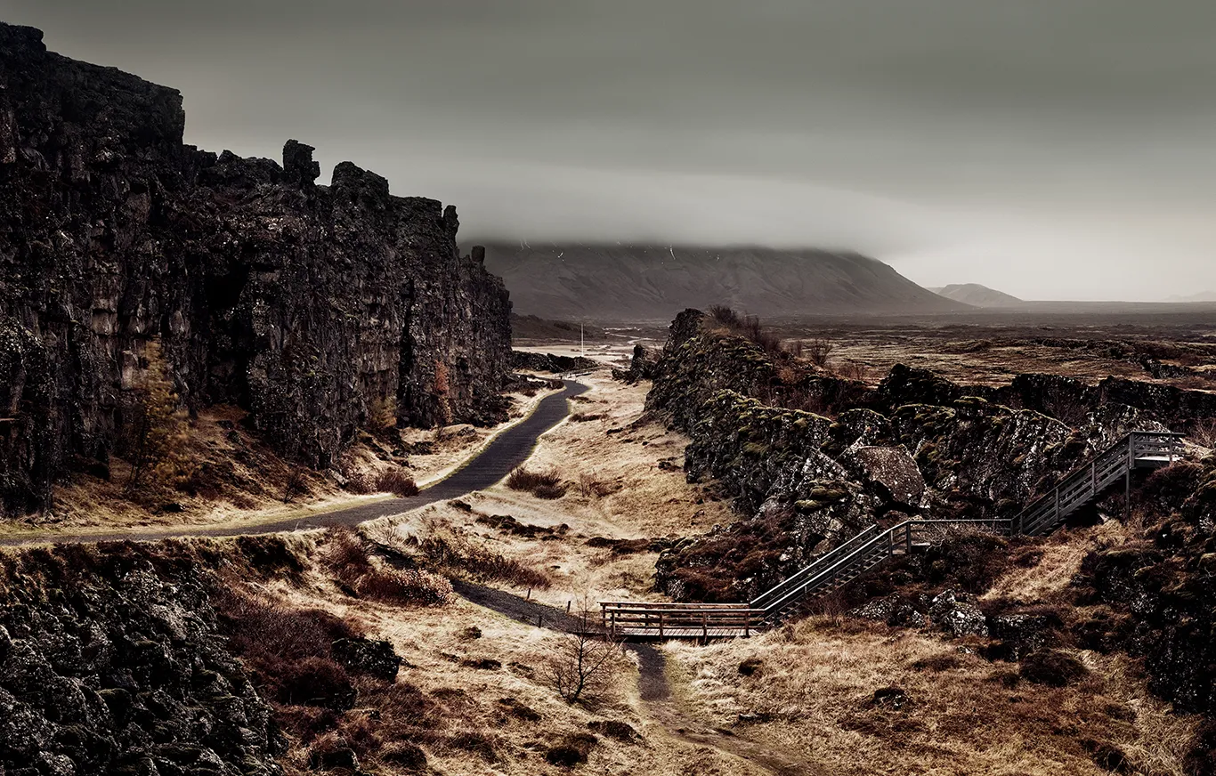 Weg zwischen dunklen Felsen auf der linken Seite in Thingvellir